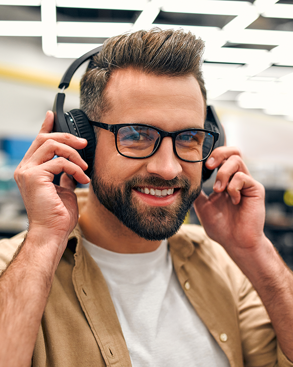 a man smiles while listening to music on wireless headphones